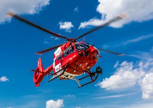 Der Rettungshelikopter im Flug über der Wolkendecke