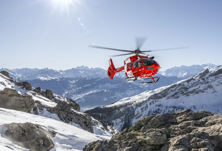 L'elicottero della Rega sorvola le montagne innevate della Svizzera
