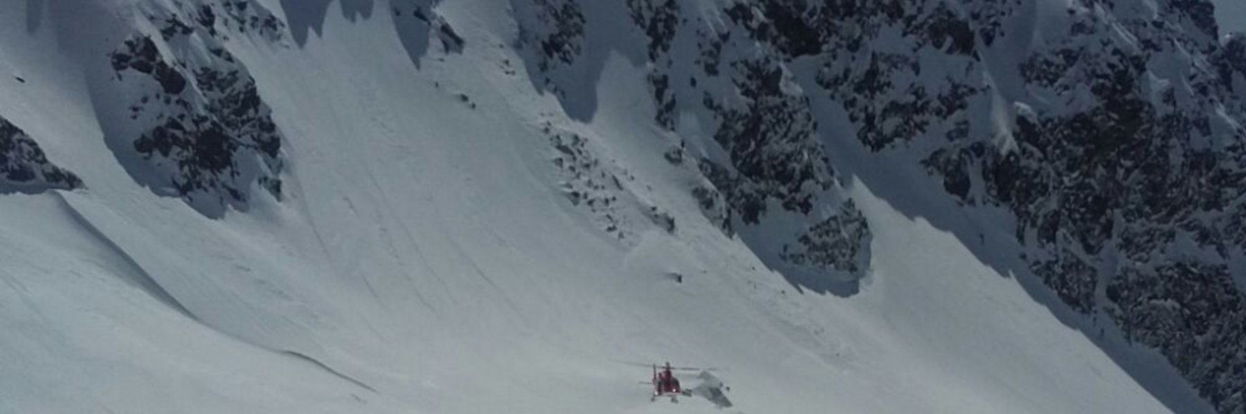 Ein Rega-Helikopter über dem Lawinenkegel am Pizzo Canà
