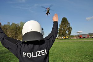 Policier indiquant à l'hélicoptère de sauvetage de la Rega le lieu de l'accident