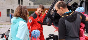 Un pilote montre à une famille le cockpit d’un hélicoptère de sauvetage