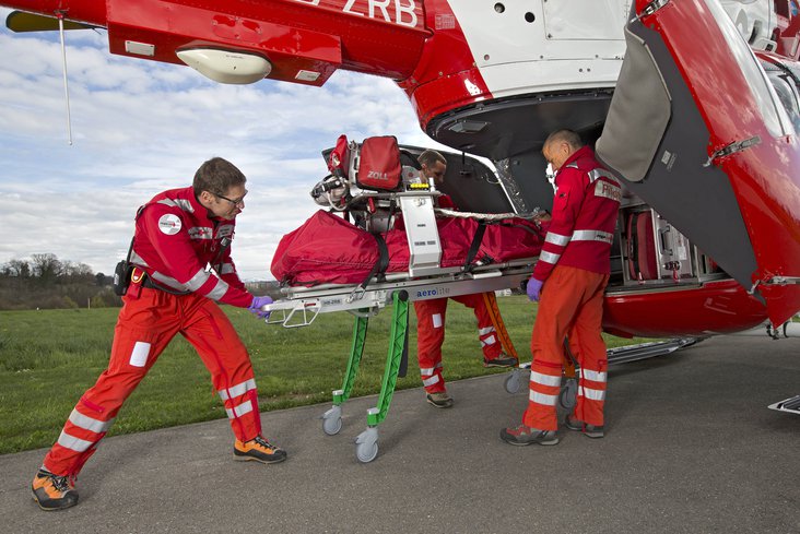 Die Rega-Crew lädt die neue Roll-in-Trage in den EC 145-Helikopter