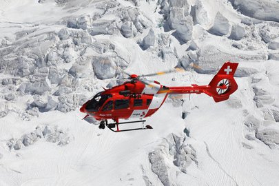Airbus H145 in front of snowy mountains