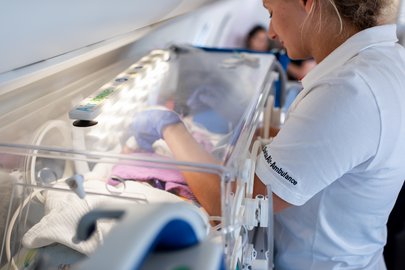 A bord de l’avion-ambulance de la Rega : pendant le vol, l’infirmière en néonatologie Nicole Grieder s’occupe avec amour d’Emilia.