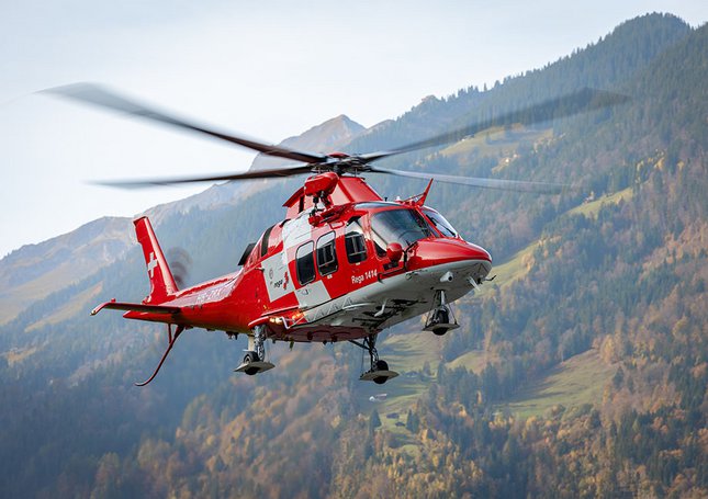 Un hélicoptère de sauvetage survole des collines boisées