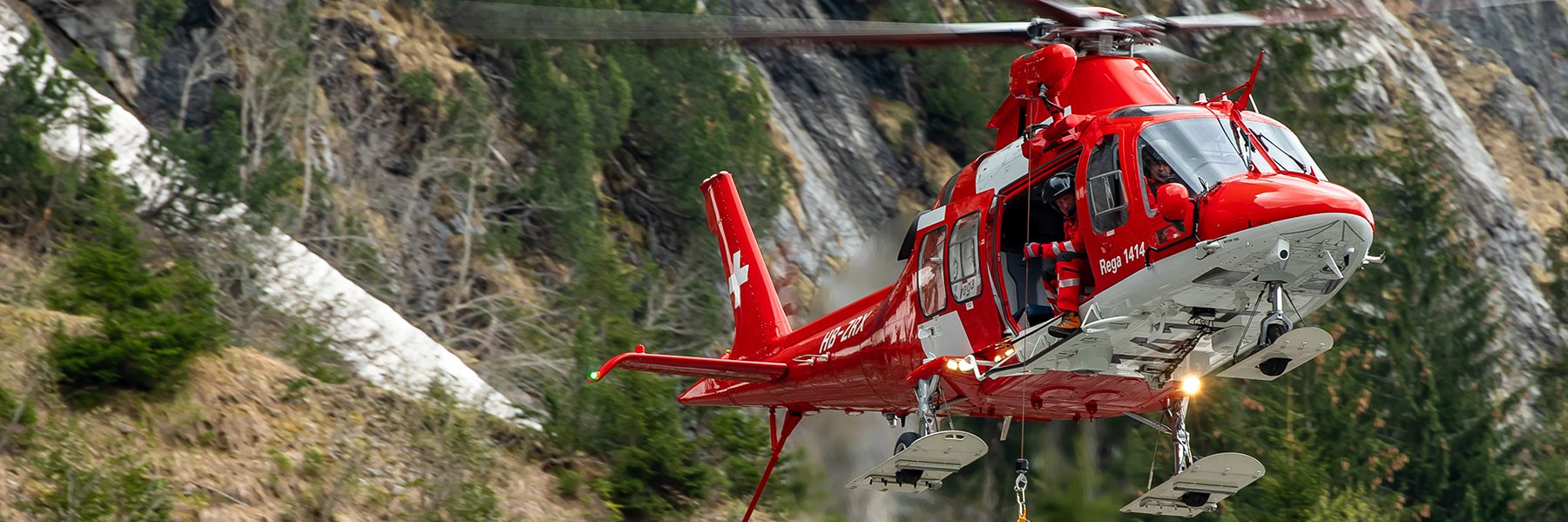 Rescue helicopter AgustaWestland Da Vinci during a rescue operation with the rescue hoist