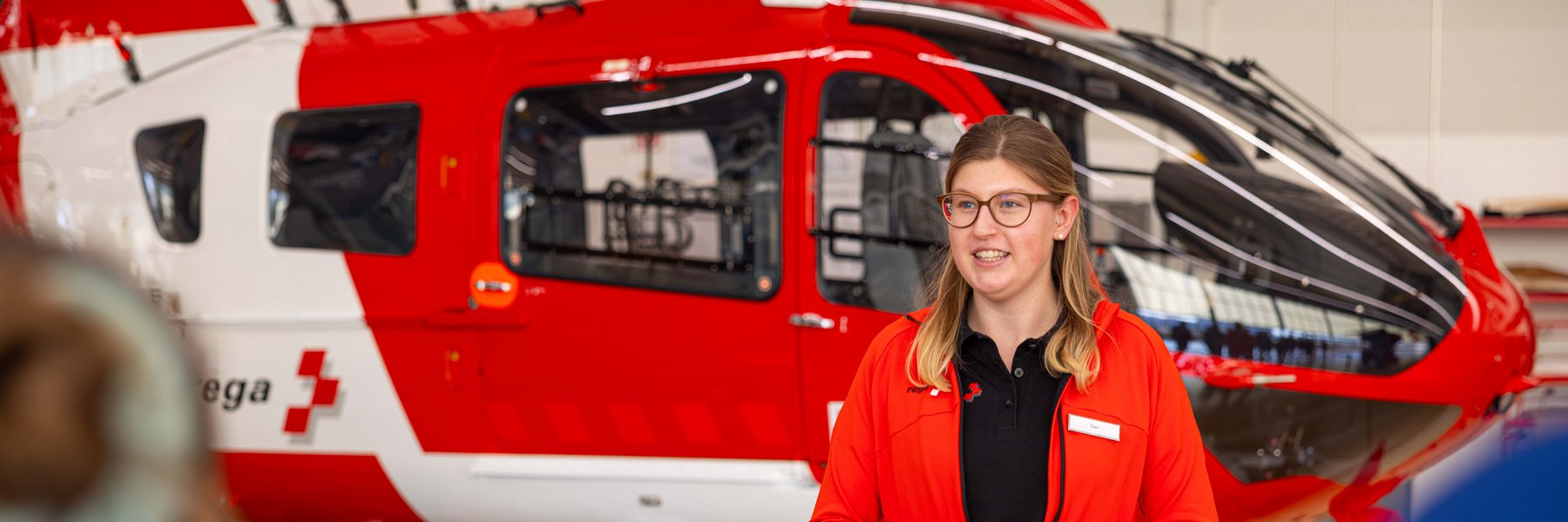 Guide at a tour in front of a rescue helicopter