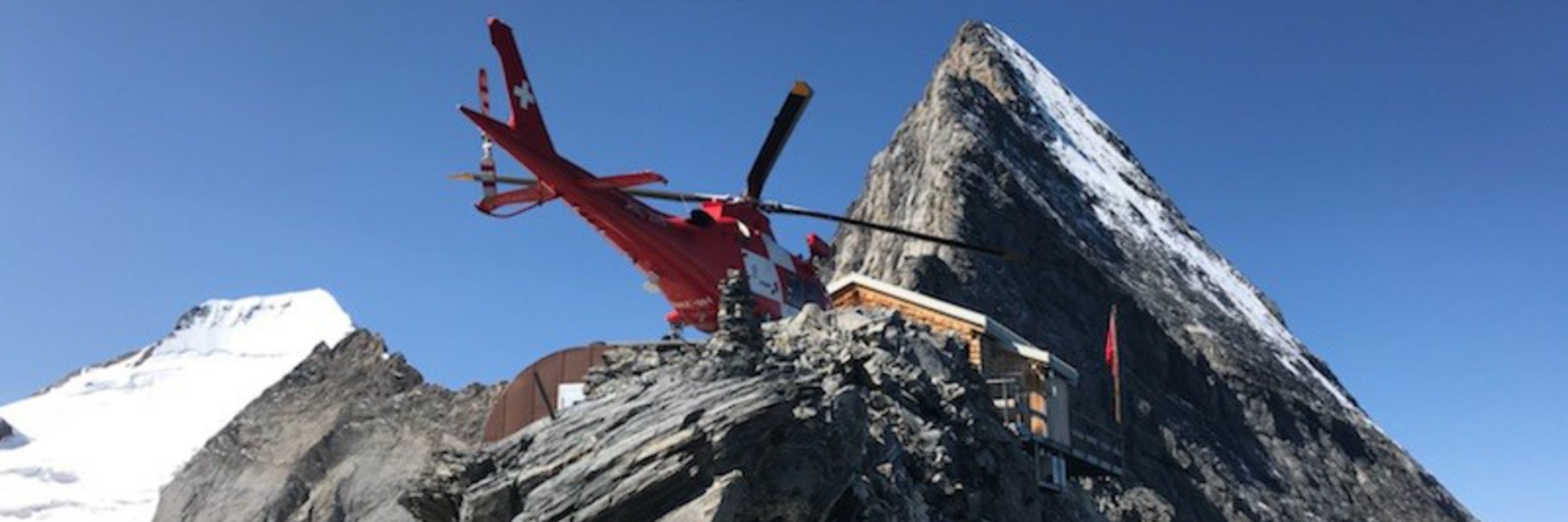 Symbolbild: Ein Rega-Helikopter auf dem Landplatz der Mittellegihütte