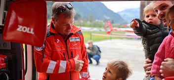 Un pilote montre à une famille un hélicoptère de sauvetage