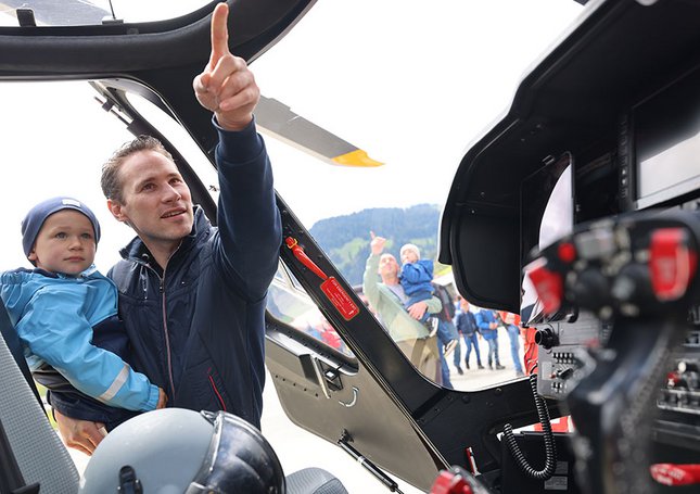 Vater und Sohn schauen sich das Cockpit des Rettungshelikopters an