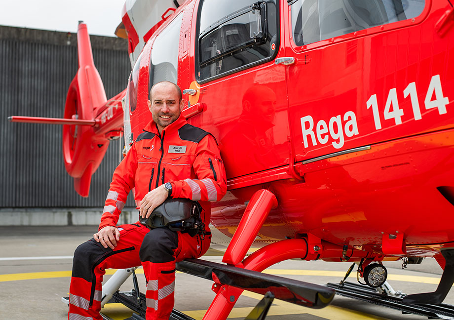 Un pilote est assis sur le marchepied d’un hélicoptère